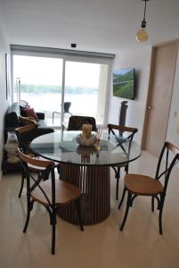 ein Wohnzimmer mit einem Glastisch und Stühlen in der Unterkunft Lujoso apartamento frente al mar in Tubará