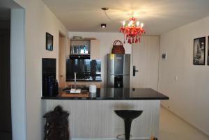 eine Küche mit einer schwarzen Theke und einem Kühlschrank in der Unterkunft Lujoso apartamento frente al mar in Tubará