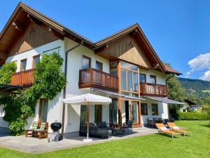 a house with a patio with chairs and an umbrella at Chalet Das Atrium in Radstadt