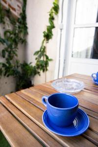 une tasse bleue et une soucoupe sur une table en bois dans l'établissement Le Petit Nicolas - Centre historique de Blois - NETFLIX, JEUX, RETROJECTEUR, à Blois