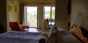 1 dormitorio con cama y vistas a un balcón en A Private Room in Paradise, Vieux Fort, en Vieux Fort