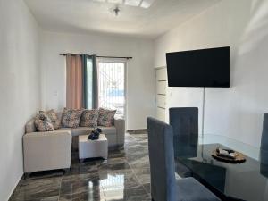 sala de estar con sofá y mesa de cristal en City Suite Apartment Cabrera, en Cabrera