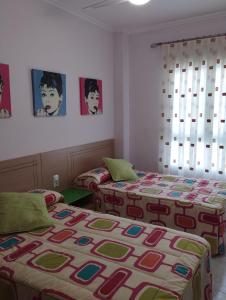 卡耐特蒂貝蘭格的住宿－APARTAMENTO NEPTUNO - CANET DE BERENGUER，墙上贴有海报的房间里设有两张床