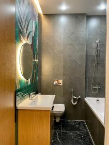 W łazience znajduje się umywalka, toaleta i lustro. w obiekcie Premium apartment Atlant w mieście Astana