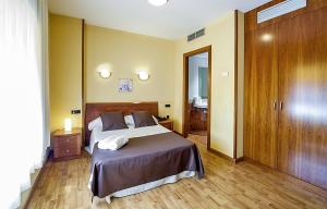 1 dormitorio con 1 cama grande y suelo de madera en Hotel Ciutat de Tarrega en Tárrega