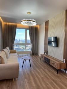 salon z kanapą i telewizorem w obiekcie Premium apartment Atlant w mieście Astana