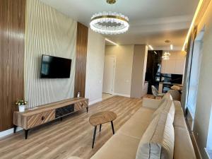 salon z kanapą i telewizorem na ścianie w obiekcie Premium apartment Atlant w mieście Astana