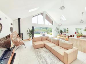 a living room with a couch and a fireplace at New build Luxurious PALMA VILLA IN CORNWALL! 4miles EDEN PROJECT, 4 miles Beach & Harbour! Open plan, One level Living area Ground floor, Private location, Encllosed Garden, Underfloor Heating, Coffee Machine,near WALKING-CYCLING PATH in St Austell
