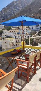 a table and chairs with a blue umbrella on a roof at Olympos Princess in Olympos