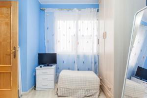 een kleine slaapkamer met een bed en een raam bij Elegante apartamento muy cerca de la playa in Valencia