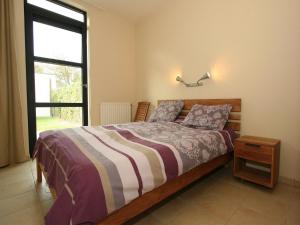 ein Schlafzimmer mit einem Bett und einem großen Fenster in der Unterkunft Maanvis in Cadzand