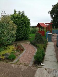 jardín con parque infantil y pasarela en Lynn's Lodge en Randalstown