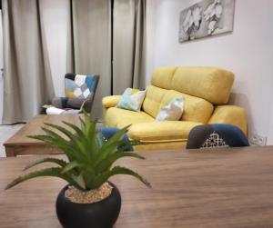 uma sala de estar com uma mesa e um sofá amarelo em Casa Margarita Confort em Ardales