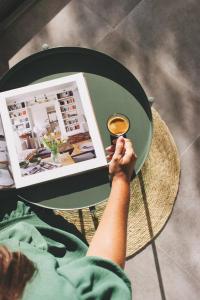 una persona sentada en una mesa con un libro y una taza de café en Casa L-N-Noa Boutique room whit private pool, en Lagos