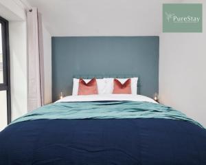 a blue bedroom with a bed with red pillows at Stunning 5 Bed House By PureStay Short Lets & Serviced Accommodation Manchester With Parking in Manchester