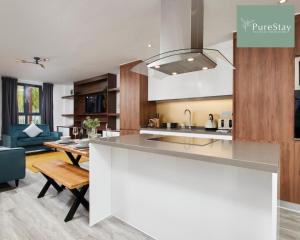 a kitchen and living room with a counter top and a table at Stunning 5 Bed House By PureStay Short Lets & Serviced Accommodation Manchester With Parking in Manchester