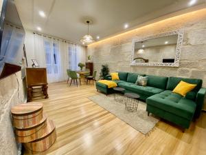 a living room with a green couch and a table at A Michelena de Pedra in Pontevedra