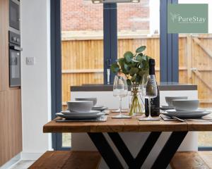 a dining table with plates and wine glasses at Stunning 5 Bed House By PureStay Short Lets & Serviced Accommodation Manchester With Parking in Manchester