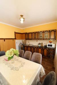 ein Esszimmer mit einem Tisch und einer Küche in der Unterkunft Cottage "Lure" in Jaremtsche