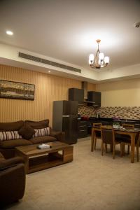 Juffair Trends Luxury Apartment في الجفير: غرفة معيشة مع أريكة وطاولة