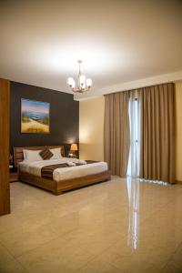 Habitación grande con cama y lámpara de araña. en Juffair Trends Luxury Apartment, en Juffair