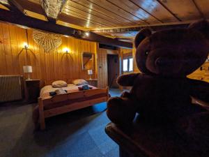 un osito de peluche grande en un dormitorio con cama en Belle Vue Des Praz, en Chamonix-Mont-Blanc