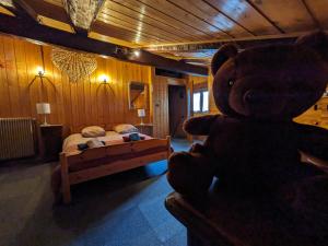 a large teddy bear in a bedroom with a bed at Belle Vue Des Praz in Chamonix-Mont-Blanc