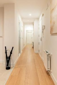 a hallway with a wooden floor and white walls at OT Residence 5 bedrooms 4 bathrooms luxury apartment in Old Town in Bilbao