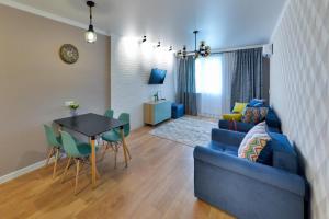sala de estar con sofá azul y mesa en Apartment Lazurniy 7Б en Astaná