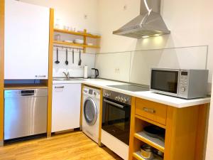 eine Küche mit einer Mikrowelle, einer Waschmaschine und einem Trockner in der Unterkunft Alles komplett: Zwei Schlafzimmer, große Küche, eigenes Bad in Köln
