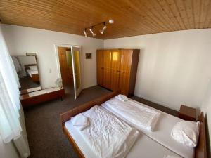 1 Schlafzimmer mit 2 weißen Betten und einer Holzdecke in der Unterkunft Haus für Monteure in Baden-Baden in Baden-Baden