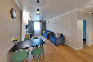 sala de estar con mesa, sillas y sofá en Apartment Lazurniy 7Б en Astaná