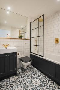 a bathroom with a toilet and a sink and a tub at Sea Cove in Hope-Cove