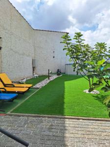 einen Garten mit Gartenstühlen und einem Gebäude in der Unterkunft Alojamento Local Terreiro in Pombal