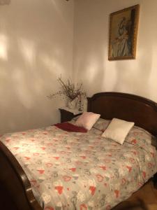 un letto con due cuscini e una foto sul muro di La Belle Maison a Siena