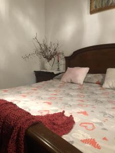 Una cama con una manta roja encima. en La Belle Maison, en Siena