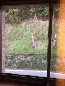 une fenêtre donnant sur un champ avec des panneaux. dans l'établissement La Belle Maison, à Sienne