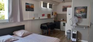 ein Schlafzimmer mit einem Bett und eine kleine Küche in der Unterkunft Appartement/studio dans petite résidence calme in La Ciotat