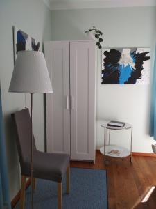 a room with a chair and a lamp and a door at Privatpension Waldbröl in Waldbröl