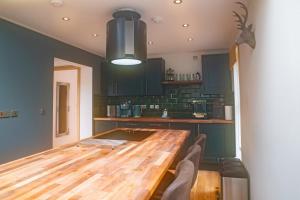 a kitchen with a wooden table and some chairs at Luxury Cottage With Stunning Views Near Fairy Pools! in Carbost