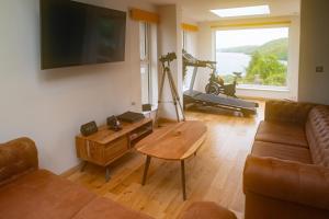 a living room with a couch and a table at Luxury Cottage With Stunning Views Near Fairy Pools! in Carbost