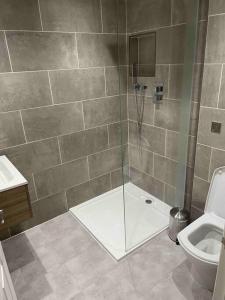 uma casa de banho com um chuveiro e um WC. em Top Floor Flat - Glasgow West End - Partick em Glasgow