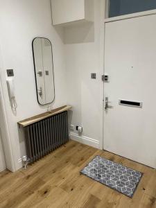 a room with a door with a mirror and a rug at Top Floor Flat - Glasgow West End - Partick in Glasgow