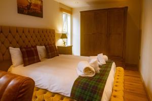 a bedroom with a large bed with towels on it at Luxury Cottage With Stunning Views Near Fairy Pools! in Carbost