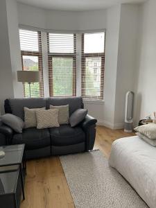 uma sala de estar com um sofá e algumas janelas em Top Floor Flat - Glasgow West End - Partick em Glasgow