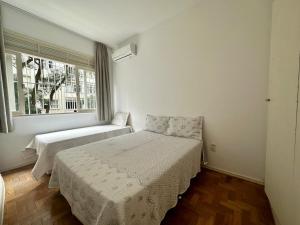 - une chambre avec 2 lits et une fenêtre dans l'établissement Amplo & Confortável - Copacabana - Posto 6, à Rio de Janeiro