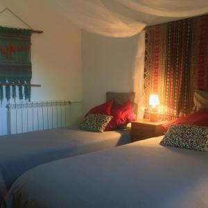 a bedroom with two beds and a table with a lamp at Vi l'Art Wine Lodge in Piera