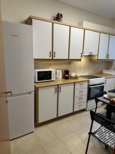 a kitchen with white cabinets and a microwave at LY Deluxe Apartment Athens in Athens