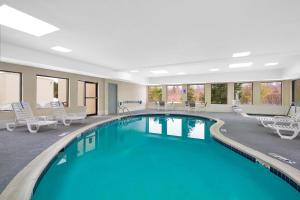 una piscina en una habitación de hotel con sillas y mesas en Holiday Inn Express Harrisburg NE, an IHG Hotel, en Manadahill