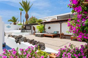 eine Villa mit einer Terrasse mit lila Blumen in der Unterkunft Villa Munay in Puerto del Carmen